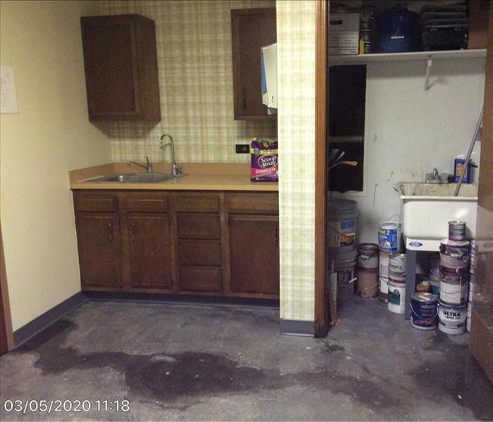closet, and kitchen cabinets and sink with water on the floor