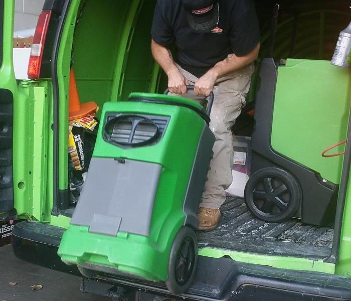 employee putting equipment in the work truck