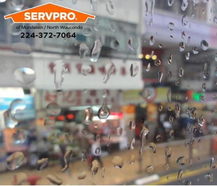 Raindrops gather on a storefront window.