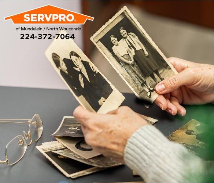 A person is looking at old black-and-white family photos.